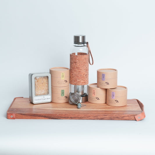 Tea Enthusiast Gift Set from Megan’s Pantry featuring a double-walled glass tea tumbler with built-in infuser, a handmade gemmed stainless steel tea infuser, candied ginger bites, and five loose leaf tea blends. A curated artisan tea gift box perfect for tea lovers, wellness routines, and everyday relaxation.