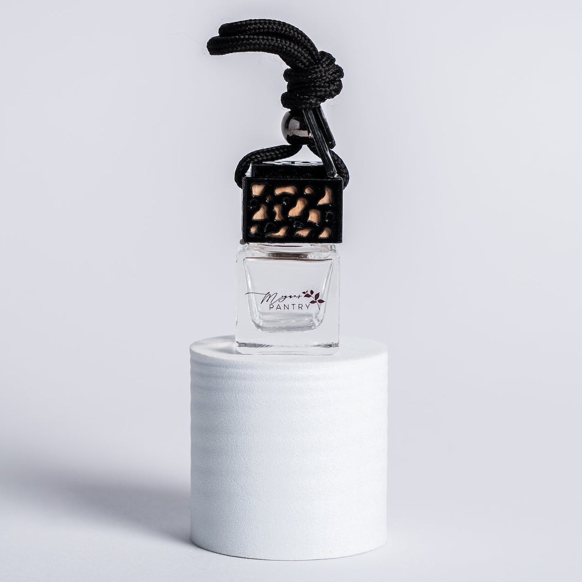 Glass hanging car diffuser with a wooden lid from Megan's Pantry, for scenting your car with essential oils.