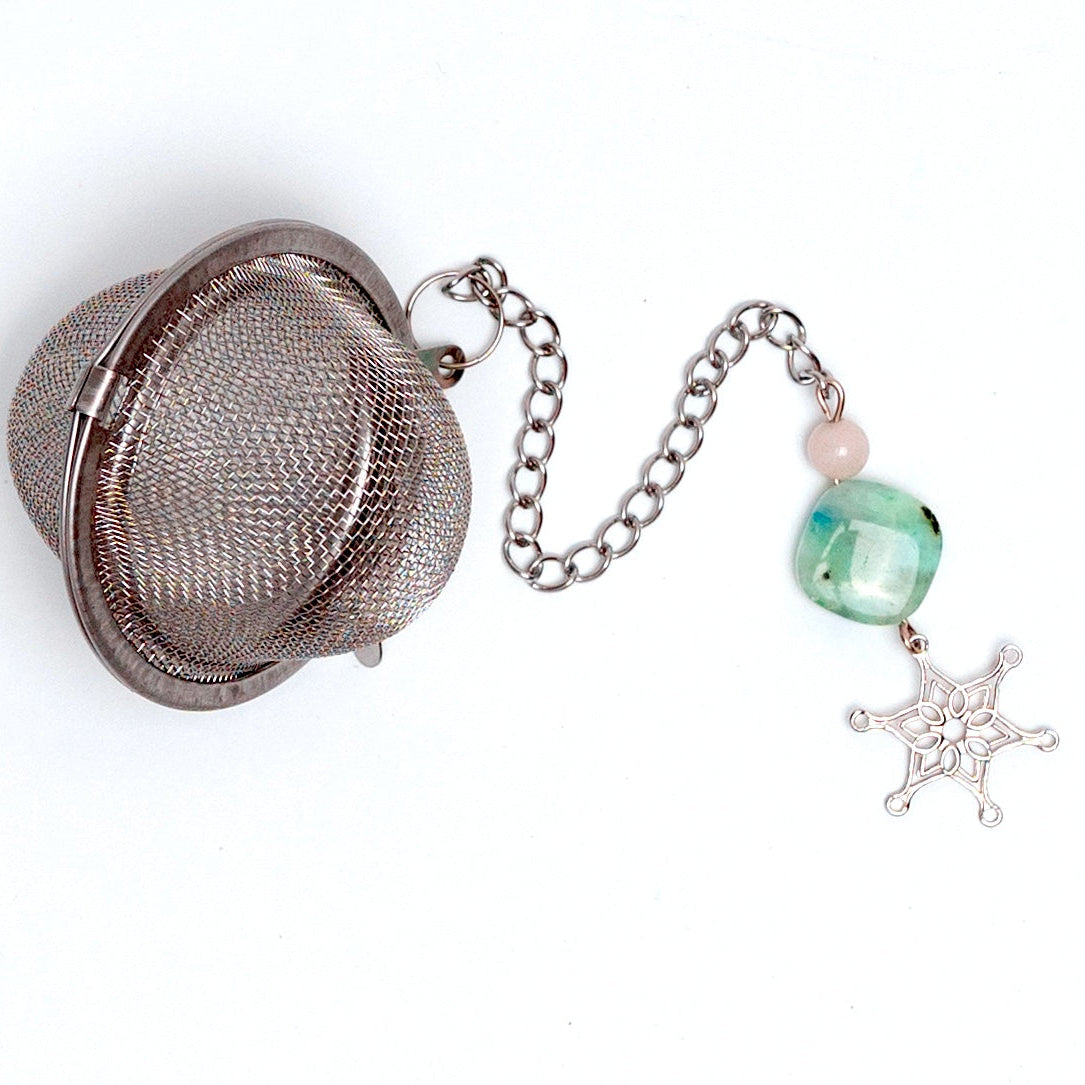 Megan’s Pantry 2025 Holiday Gift Set featuring a winter wellness tea gift box with Peppermint Dreams herbal loose leaf tea (3 oz), a hand-poured soy Winter Solstice Candle (16 oz) with pure essential oils, and a stainless steel snowflake tea ball infuser ornament displayed in a cozy, seasonal setting perfect for Christmas gifting, tea lovers, and holiday self-care.