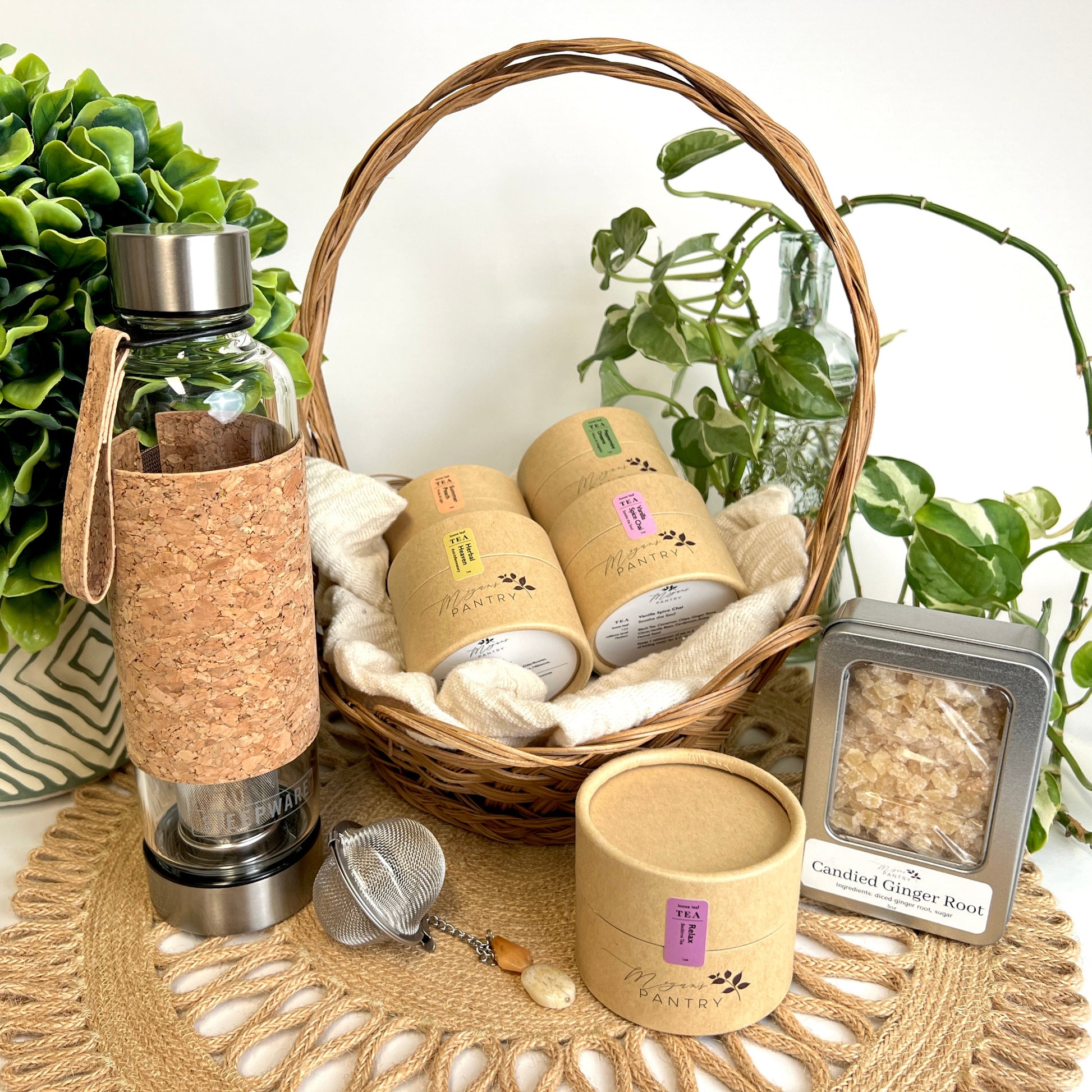 Megan’s Pantry Tea Enthusiast Gift Set featuring a premium glass Urban Tea Tumbler with built-in infuser, a gemmed stainless steel tea ball infuser (styles vary), a 5 oz bag of sulfite-free candied ginger bites, and five 1 oz pouches of artisan loose leaf tea blends — including Vanilla Spice Chai, Herbal Heaven, Peppermint Dreams, Summer Peach, and Relax Tea. A perfect tea lover’s sampler gift box for birthdays, holidays, wellness routines, or on-the-go tea enjoyment.