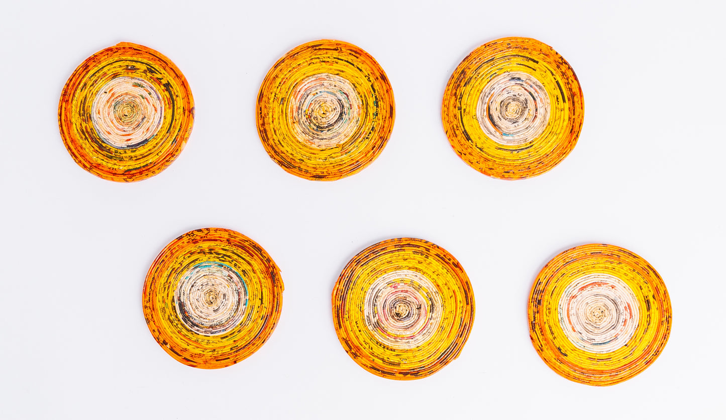 Megan’s Pantry Recycled Newspaper Coaster Set featuring six hand-crafted round coasters made from colorful upcycled newspaper, with a matching holder. Each eco-friendly coaster measures 4 inches in diameter and fits into a 4.5-inch holder. A sustainable and unique home décor gift, perfect for housewarmings, eco-conscious gifting, and colorful coffee table accessories