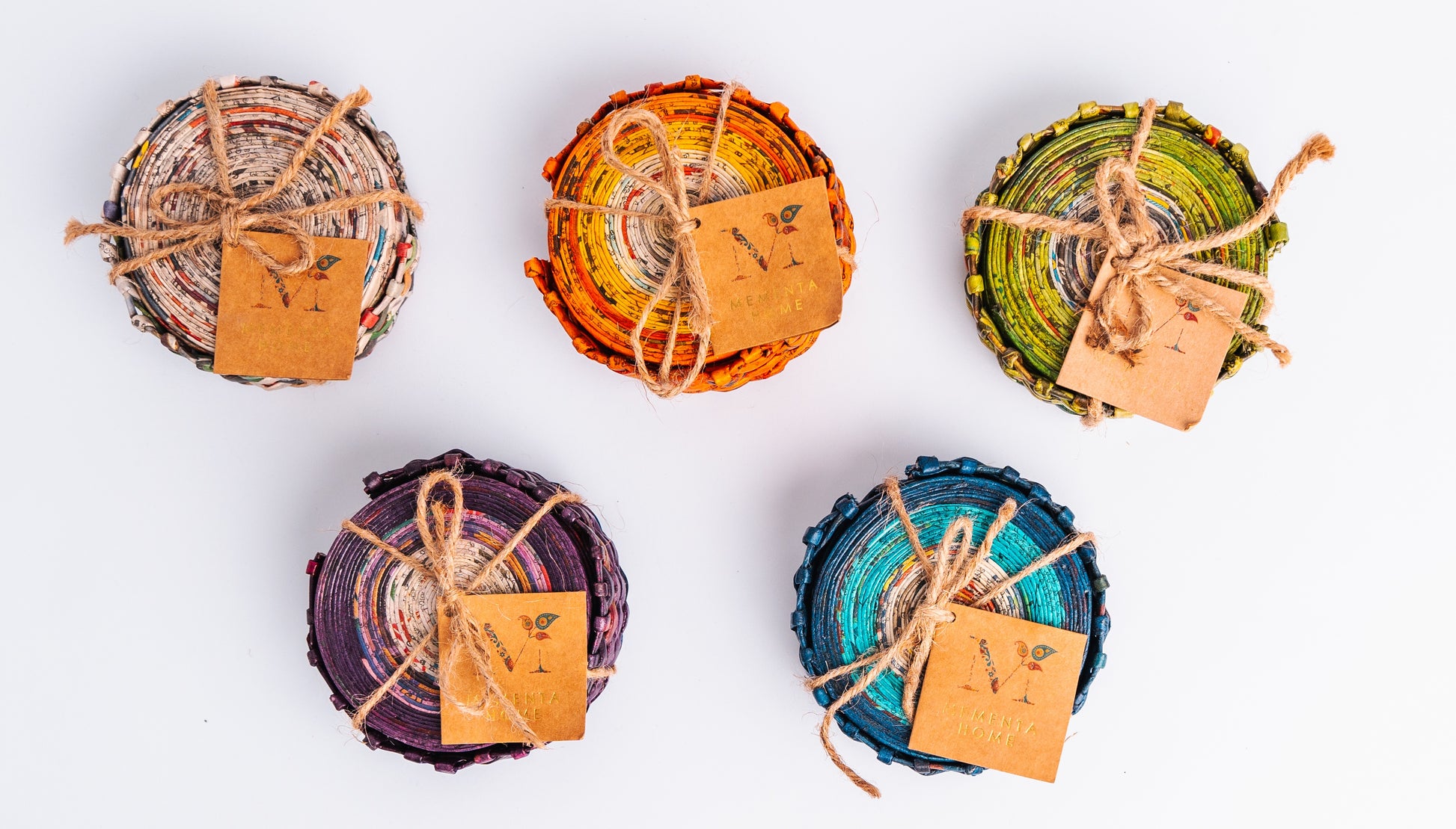Megan’s Pantry Recycled Newspaper Coaster Set featuring six hand-crafted round coasters made from colorful upcycled newspaper, with a matching holder. Each eco-friendly coaster measures 4 inches in diameter and fits into a 4.5-inch holder. A sustainable and unique home décor gift, perfect for housewarmings, eco-conscious gifting, and colorful coffee table accessories
