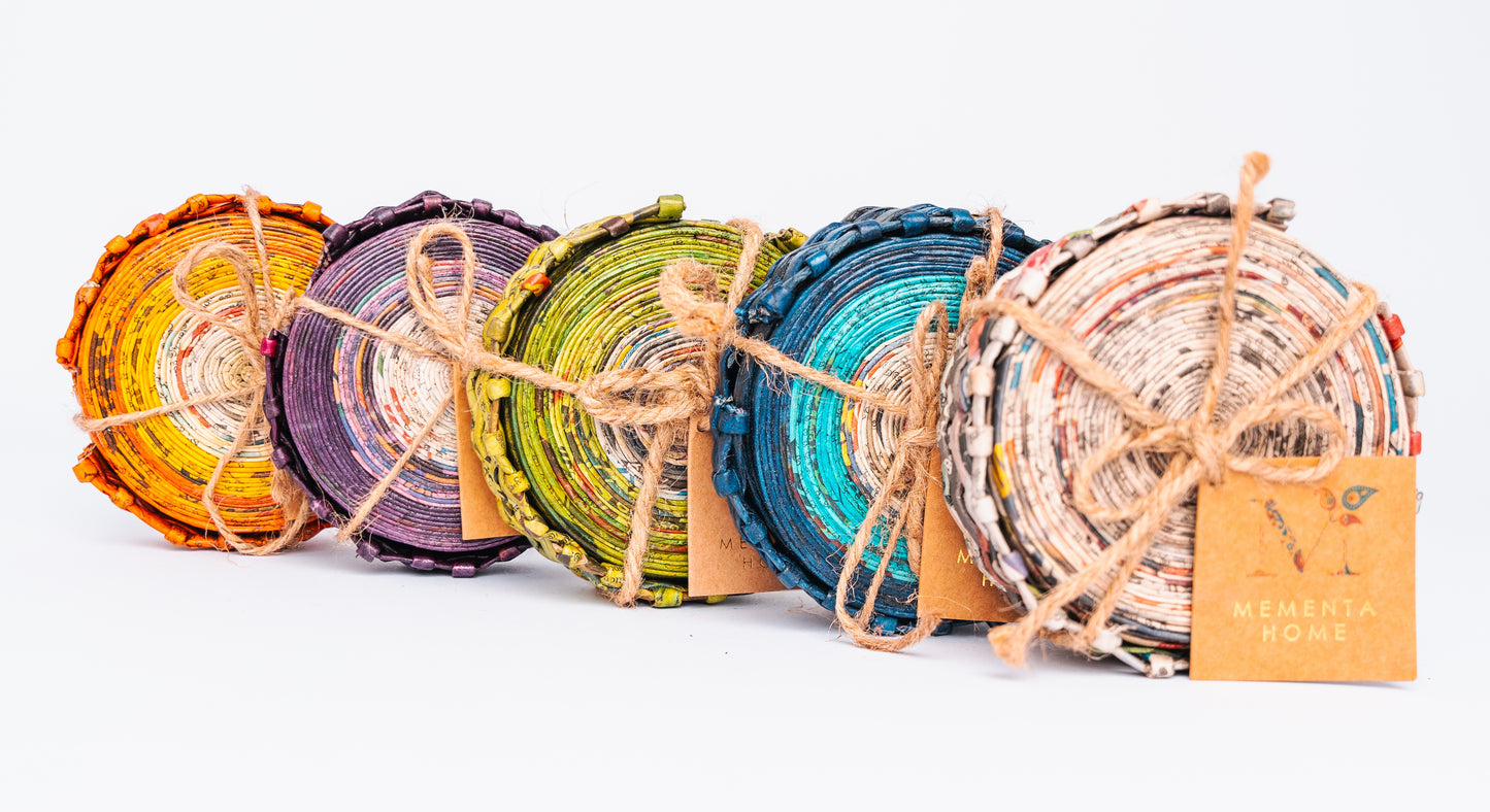 Megan’s Pantry Recycled Newspaper Coaster Set featuring six hand-crafted round coasters made from colorful upcycled newspaper, with a matching holder. Each eco-friendly coaster measures 4 inches in diameter and fits into a 4.5-inch holder. A sustainable and unique home décor gift, perfect for housewarmings, eco-conscious gifting, and colorful coffee table accessories