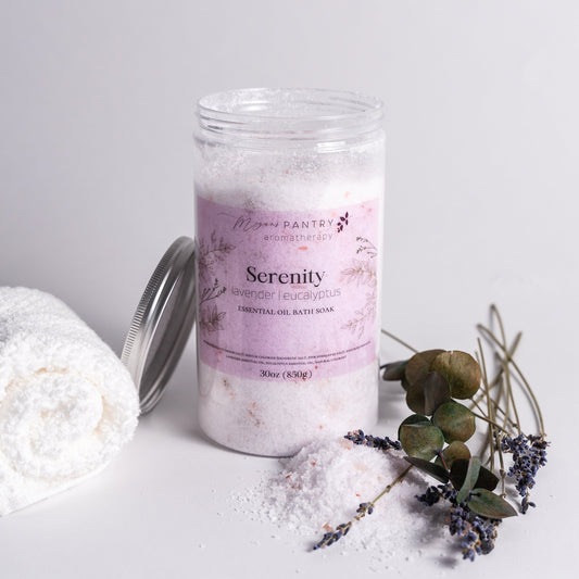 Bath salt product labeled 'Serenity' with a towel and lavender flowers on a light background
