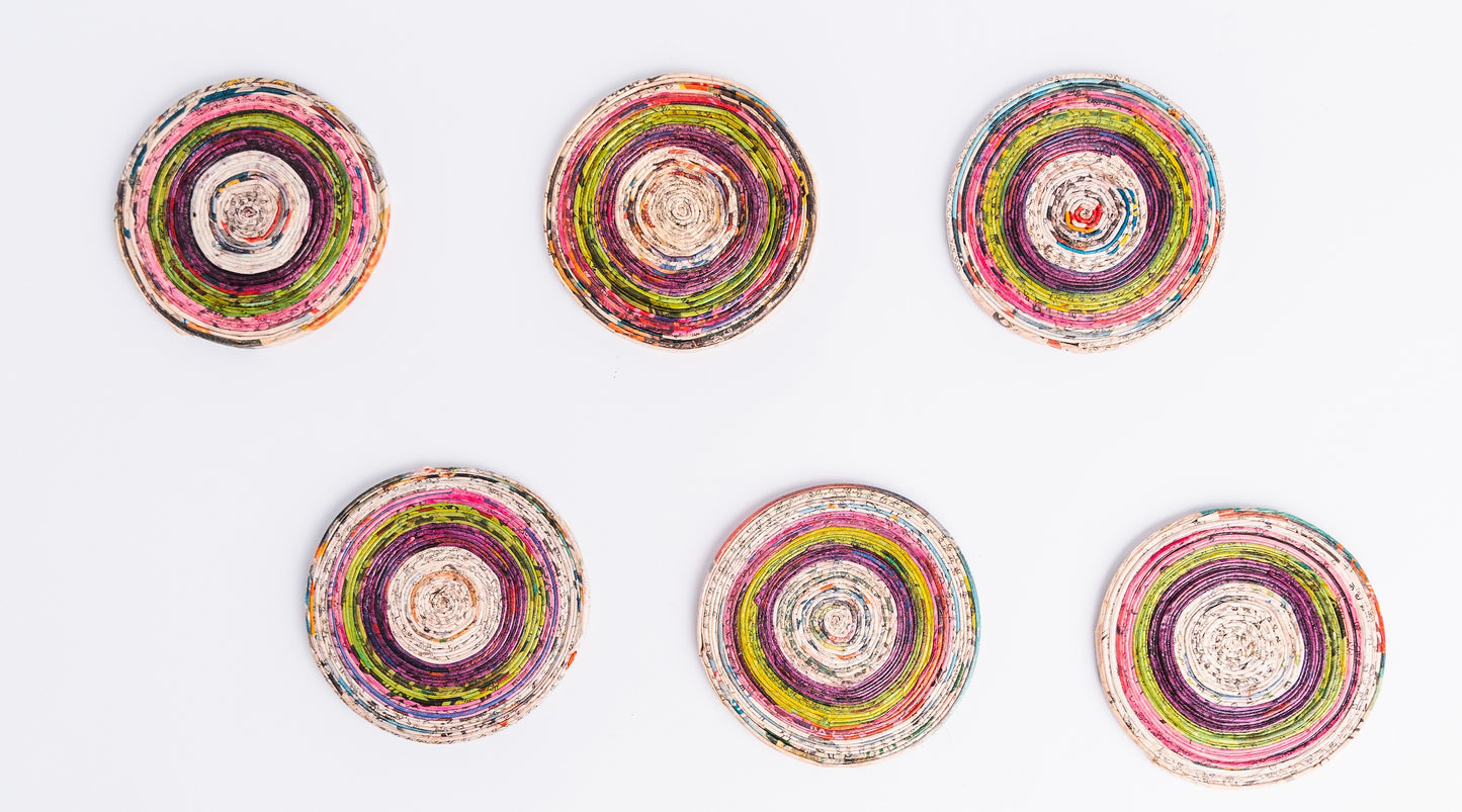 Megan’s Pantry Recycled Newspaper Coaster Set featuring six hand-crafted round coasters made from colorful upcycled newspaper, with a matching holder. Each eco-friendly coaster measures 4 inches in diameter and fits into a 4.5-inch holder. A sustainable and unique home décor gift, perfect for housewarmings, eco-conscious gifting, and colorful coffee table accessories