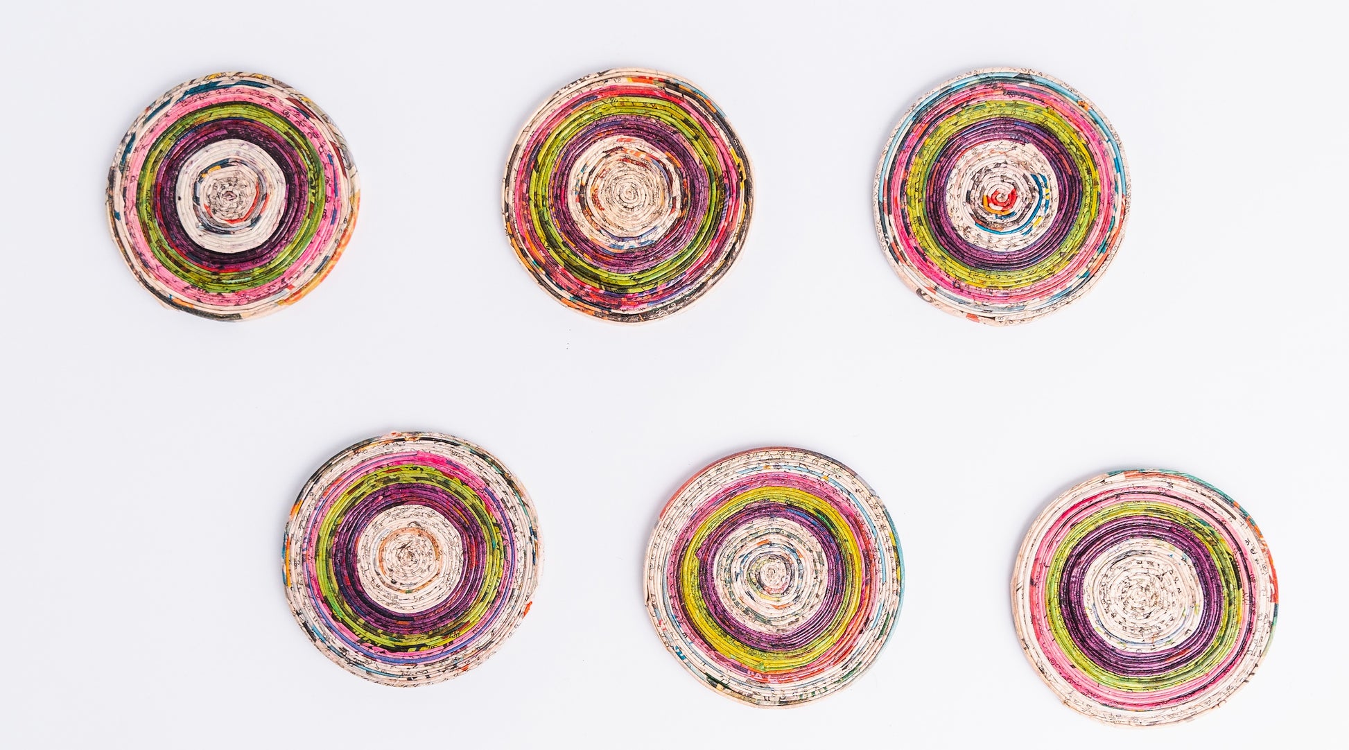 Megan’s Pantry Recycled Newspaper Coaster Set featuring six hand-crafted round coasters made from colorful upcycled newspaper, with a matching holder. Each eco-friendly coaster measures 4 inches in diameter and fits into a 4.5-inch holder. A sustainable and unique home décor gift, perfect for housewarmings, eco-conscious gifting, and colorful coffee table accessories